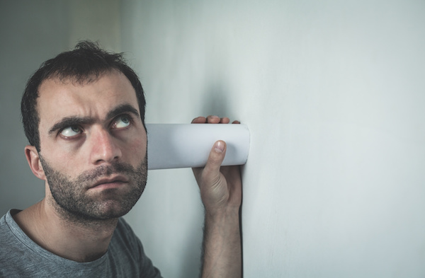 Caucasian man listening through the wall.